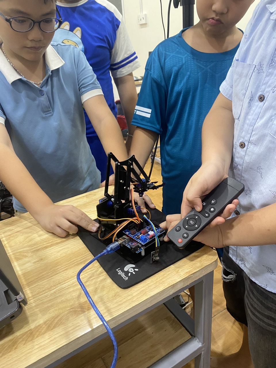 Students ages 7–13 learning programming and working in groups in class